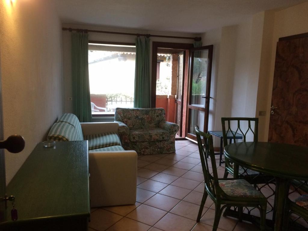 a living room with a couch and a table and chairs at Appartamento in Rudargia Residence in Porto Rotondo