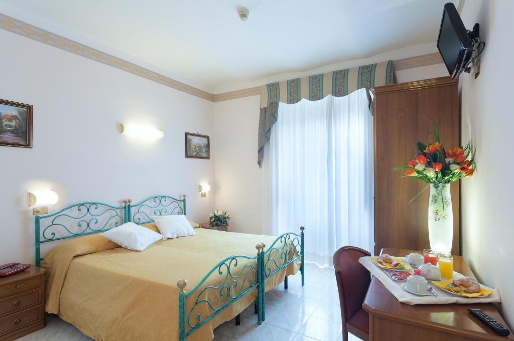 ローマにあるホテル オリエンテのベッドルーム1室(ベッド1台、テーブル、食べ物付)