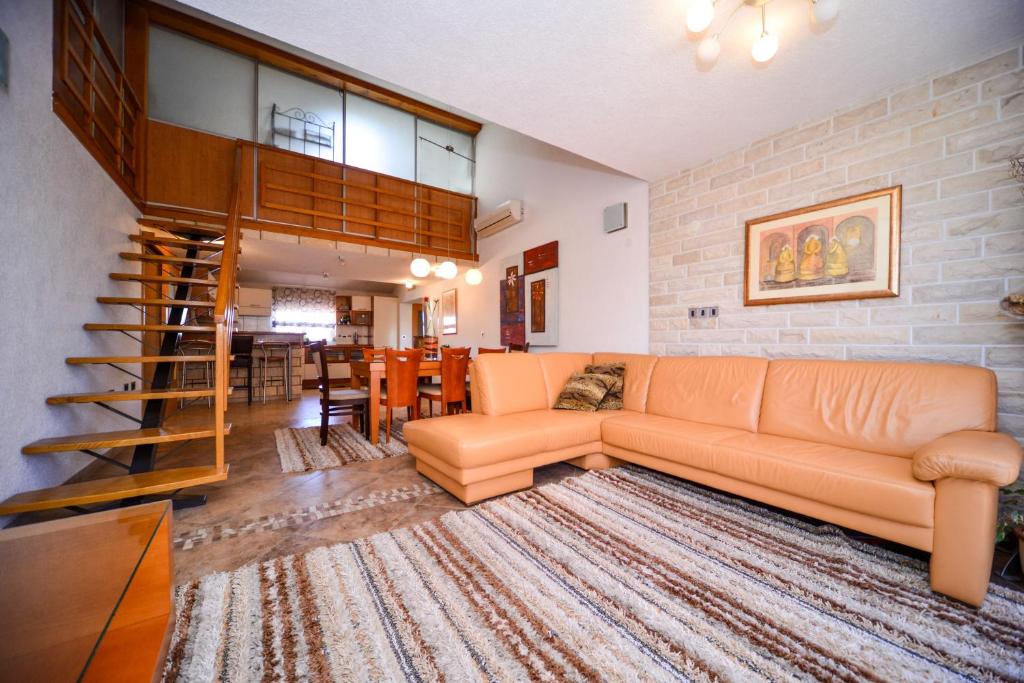 - un salon avec un canapé et une salle à manger dans l'établissement Apartman Ksenija, à Zadar