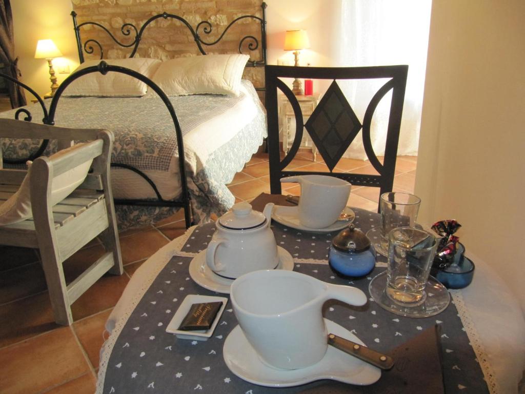 um quarto com uma cama e uma mesa com conjuntos de chá em Acquamarina B&B Casa vacanze em Marina di Montemarciano
