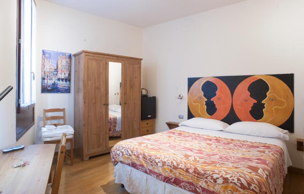 a bedroom with a bed with a large headboard at Ai Tagliapietra in Venice