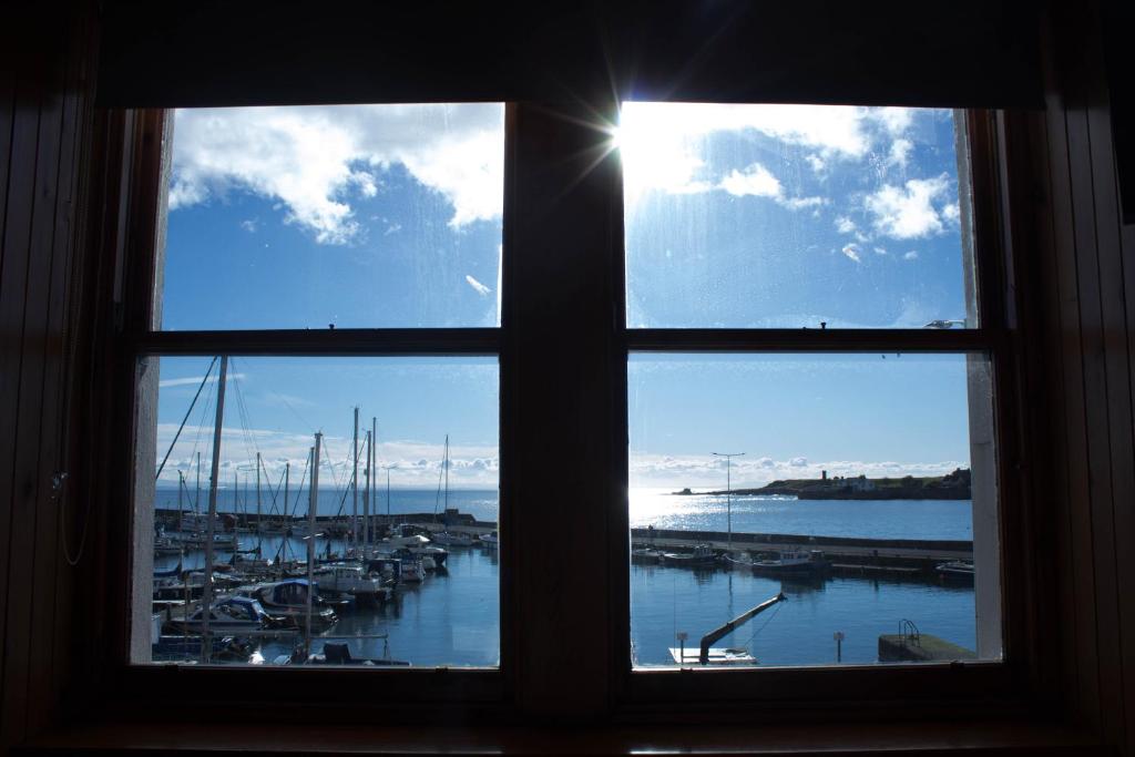 アンストラザーにあるThe Boathouseの窓から水上のボートが浮かぶマリーナを望めます。