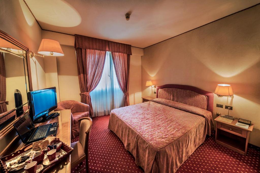 蒙特瓦爾基的住宿－瓦爾達諾酒店，酒店客房配有一张床和一张带电脑的书桌