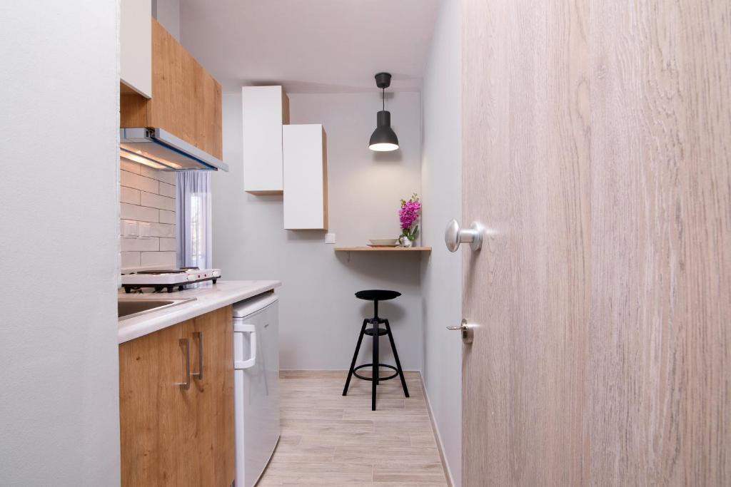 eine Küche mit einer Tür, die sich zu einer Küche mit einem Stuhl öffnet in der Unterkunft Homelia in Limenaria