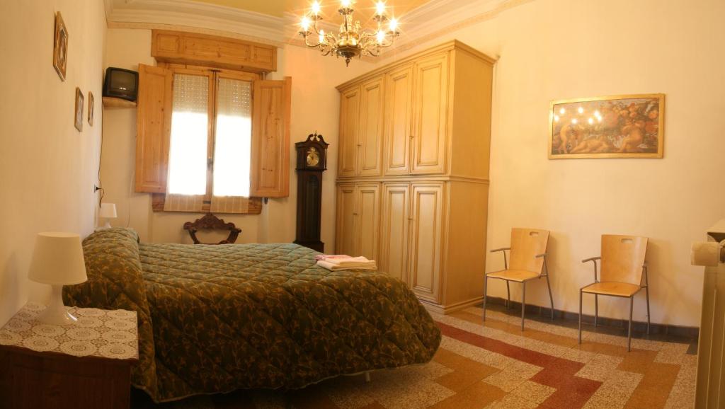 a bedroom with a bed and two chairs and a clock at A Beautiful Florence in Florence