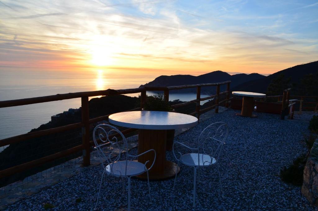 eine Terrasse mit 2 Tischen und Stühlen bei Sonnenuntergang in der Unterkunft Cadè Ventu in Vernazza