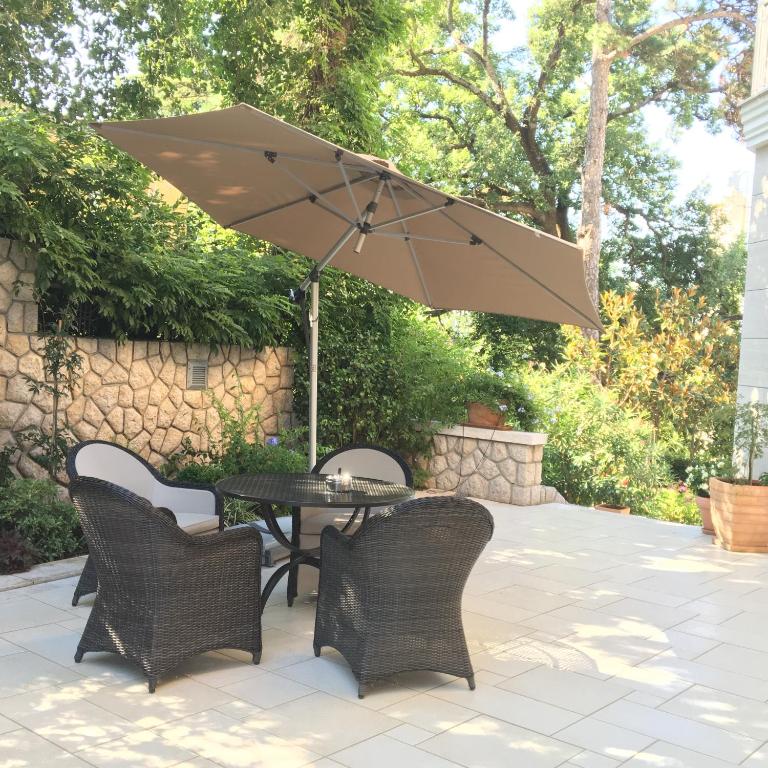 a table and chairs with an umbrella on a patio at Guest House Villa Dagmar in Crikvenica