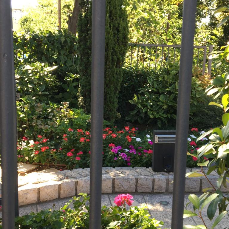 a garden with colorful flowers and a fence at Guest House Villa Dagmar in Crikvenica