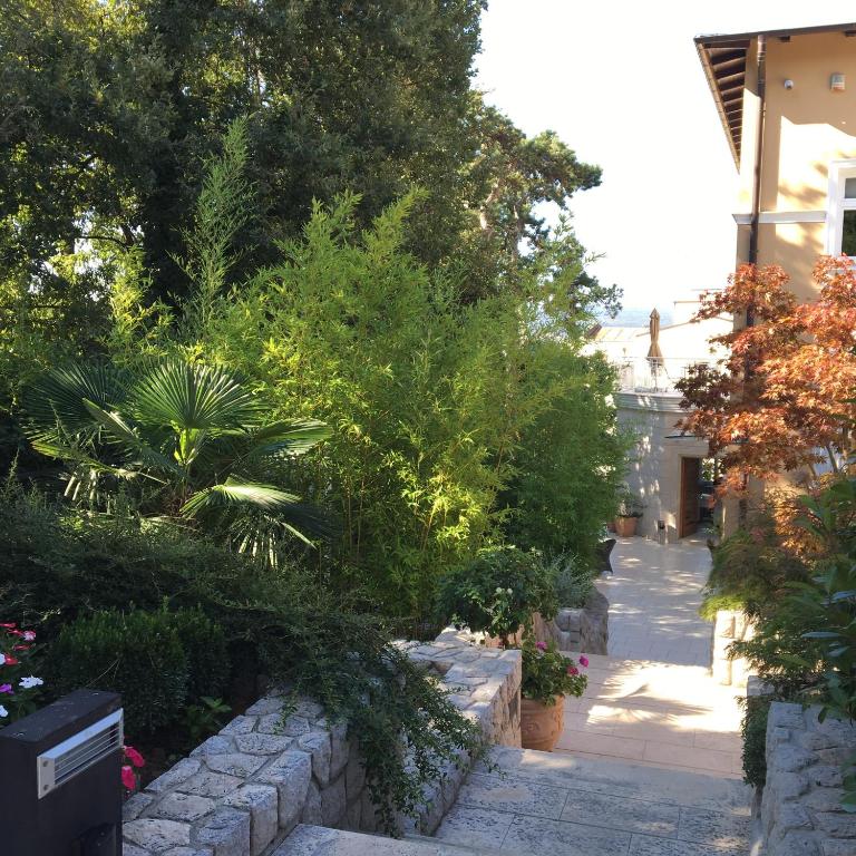a garden with plants and trees and a walkway at Guest House Villa Dagmar in Crikvenica