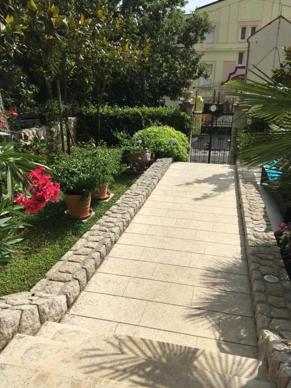 a stone walkway with potted plants on the side at Guest House Villa Dagmar in Crikvenica