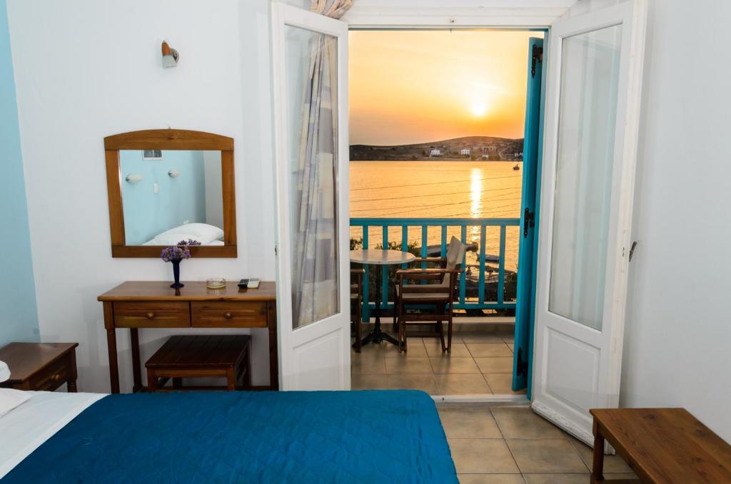 een slaapkamer met een bed en uitzicht op de oceaan bij Hotel Livadia in Parikia