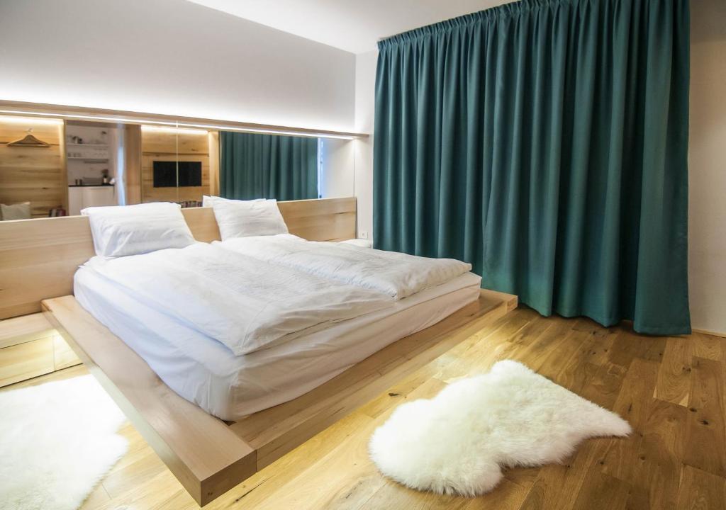 a bedroom with a large white bed and a green curtain at Garden House in Timişoara