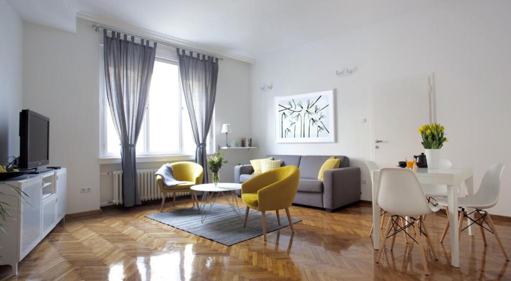 ein Wohnzimmer mit einem Sofa, einem Tisch und Stühlen in der Unterkunft Premium Class Apartments II in Zagreb