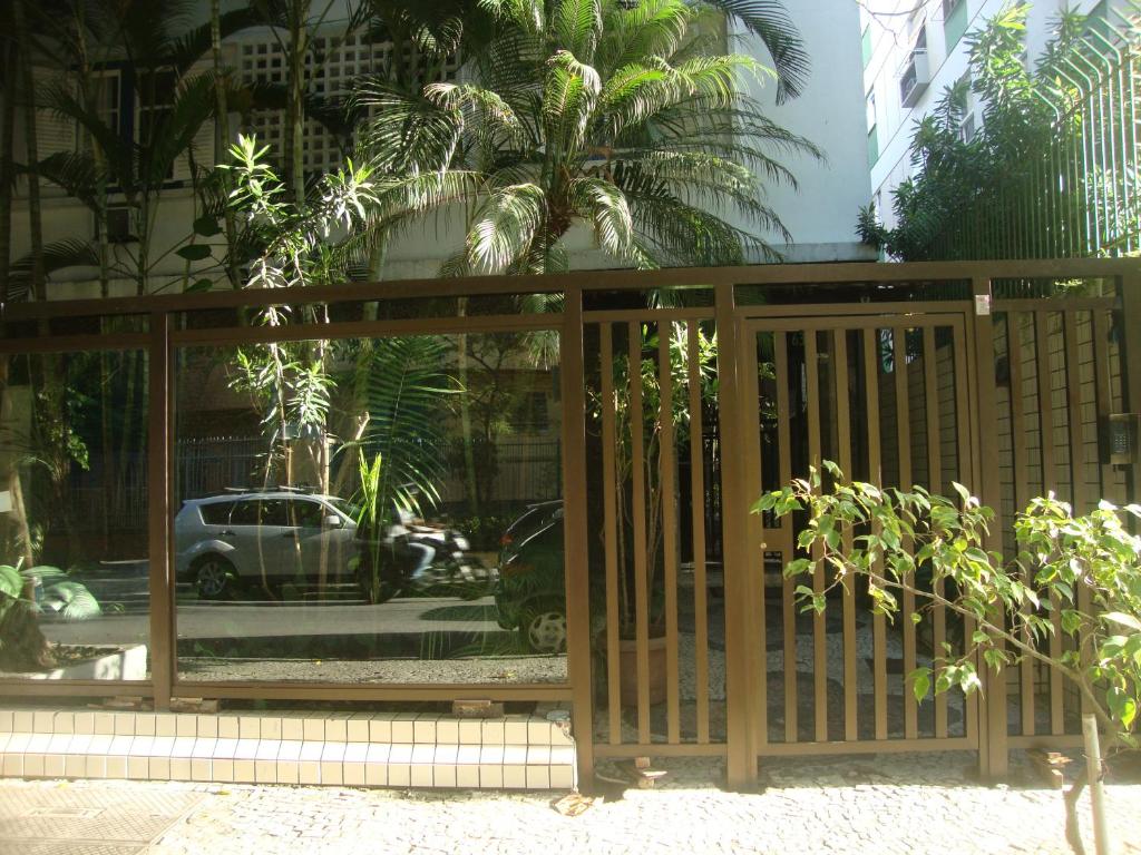 Apartamento Barão da Torre في ريو دي جانيرو: بوابة خشبية فيها انعكاس لسيارة في شباك
