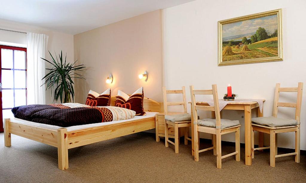 a bedroom with a bed and a table and chairs at Ferienwohnungen Altenberg ERZ 060 in Am Donnerberg