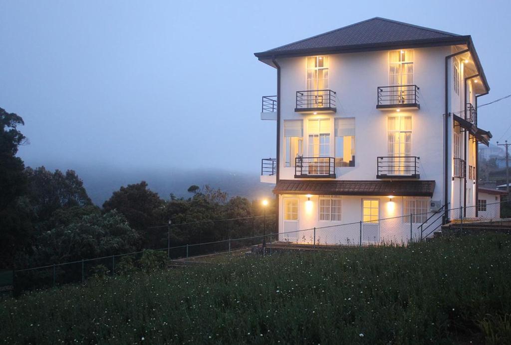 een wit huis met de lichten aan 's nachts bij Tranquil Villa in Nuwara Eliya