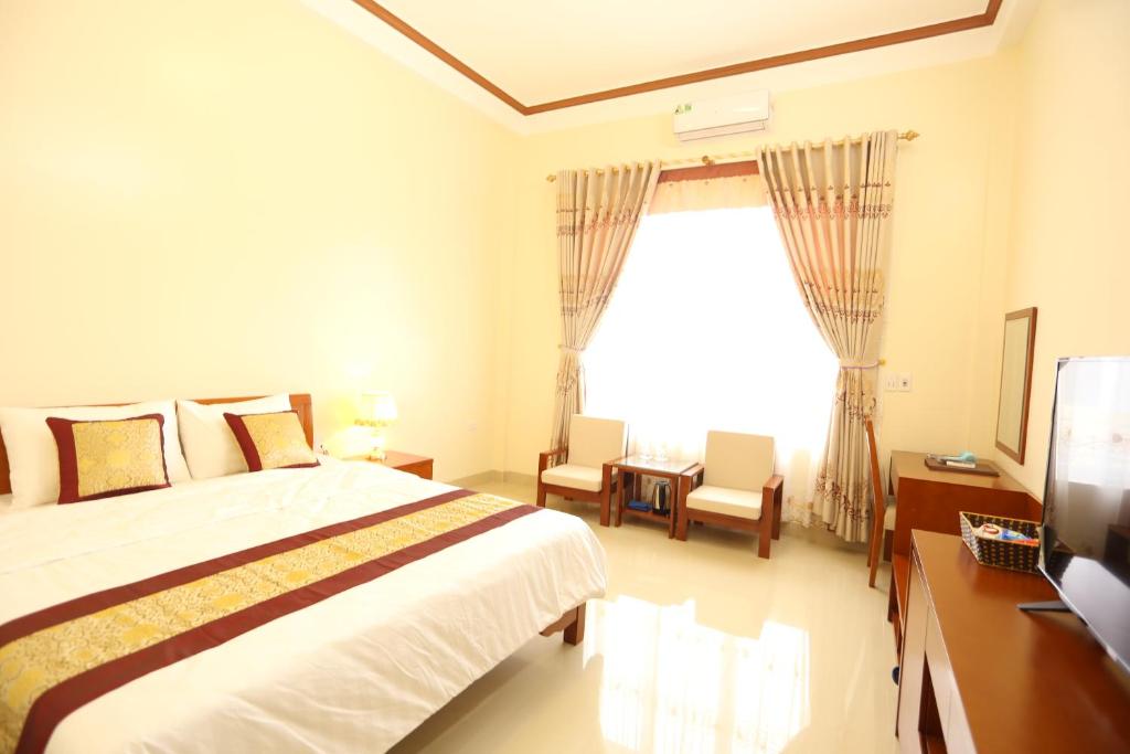 a bedroom with a large bed and a window at Royal Hotel Ha Giang in Ha Giang
