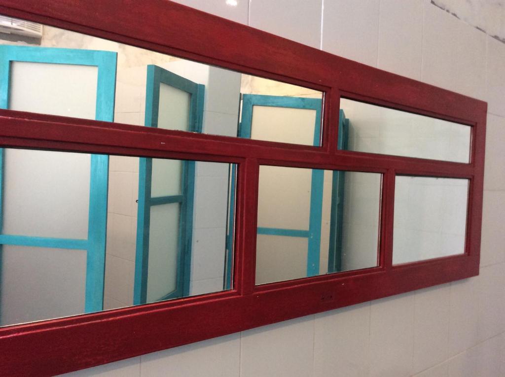 a red window on the side of a wall at The Patio Yogya in Yogyakarta