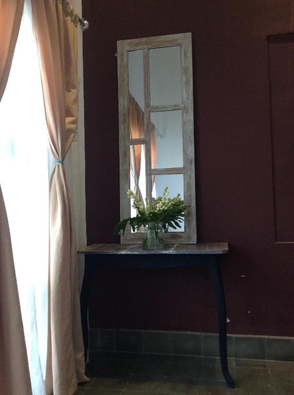 a mirror on a table with a vase of flowers at The Patio Yogya in Yogyakarta