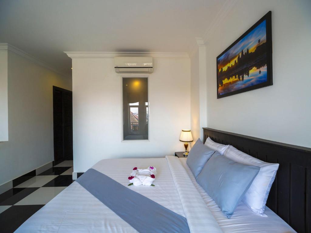 Postel nebo postele na pokoji v ubytování Rithy Rine Angkor Residence