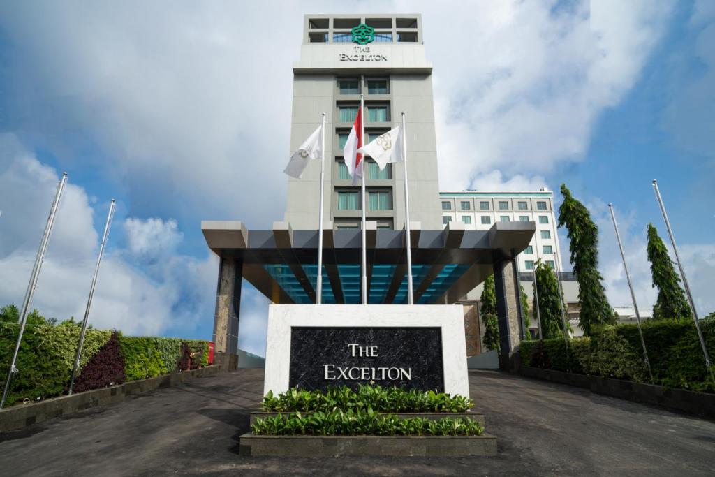 un bâtiment avec un panneau devant lui dans l'établissement The Excelton Hotel, à Palembang