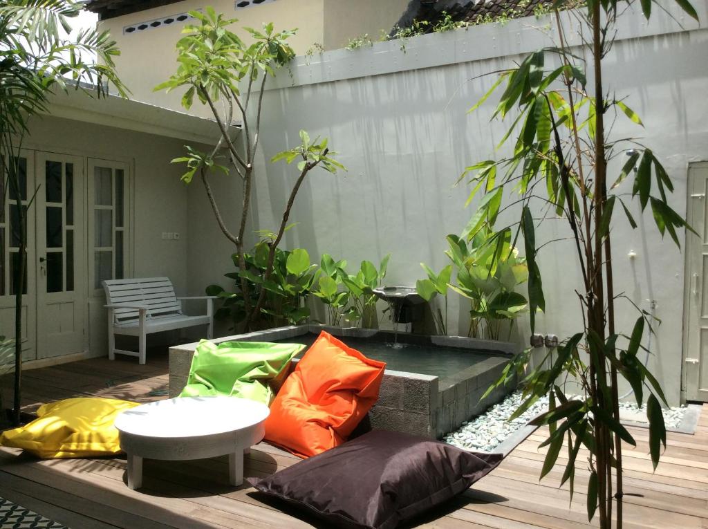 un patio con almohadas coloridas en una terraza de madera en The Patio Yogya en Yogyakarta