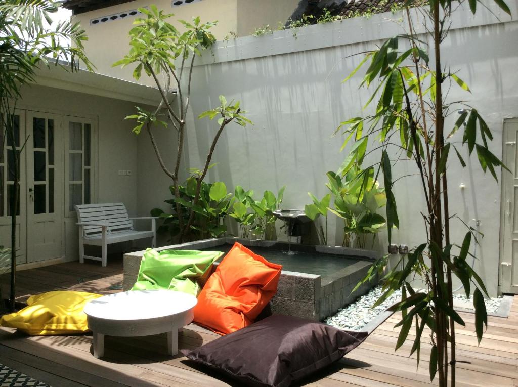 a patio with colorful pillows on a wooden deck at The Patio Yogya in Yogyakarta