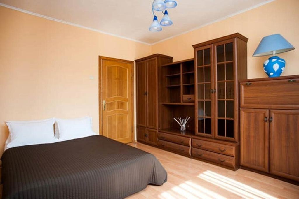 モスクワにあるInnDays on Belyaevo 24のベッドルーム1室(ベッド1台付)、木製キャビネットが備わります。