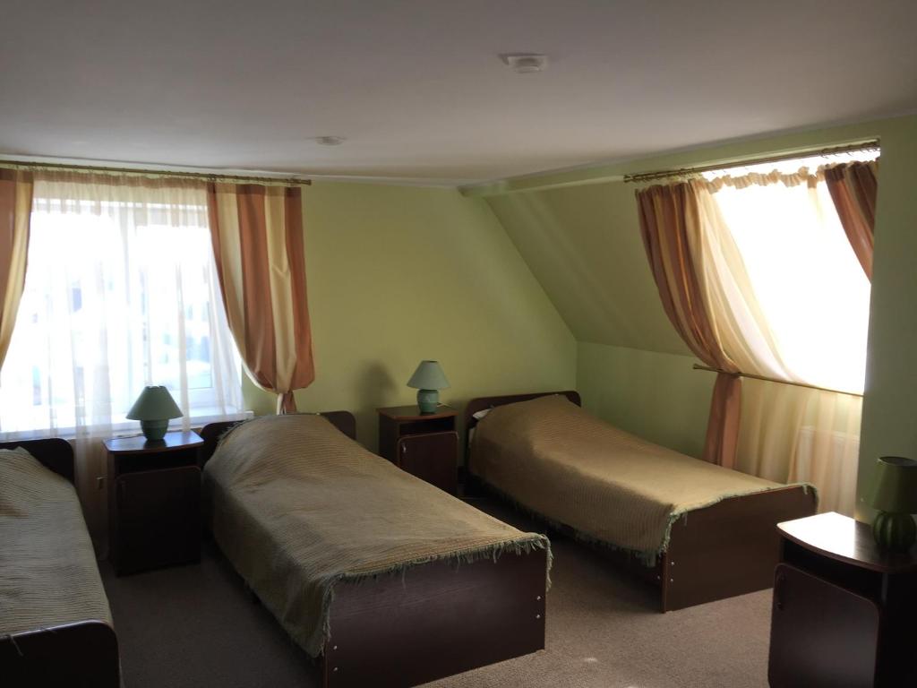 a hotel room with two beds and two windows at Motel Prival in Yelets