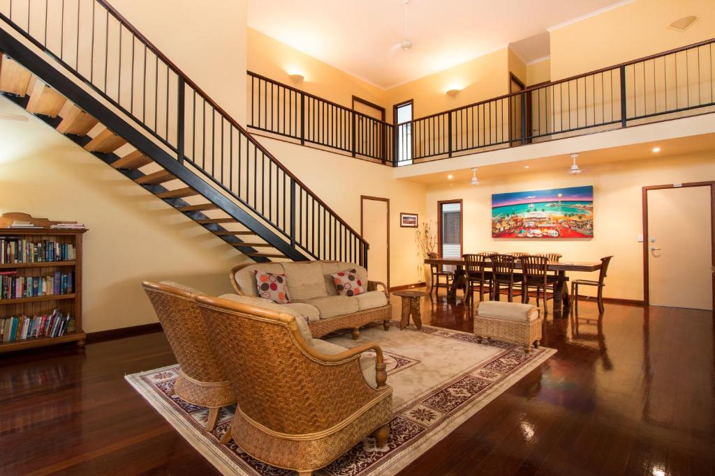 a living room with a staircase and a dining room at The Courthouse Bed & Breakfast in Broome