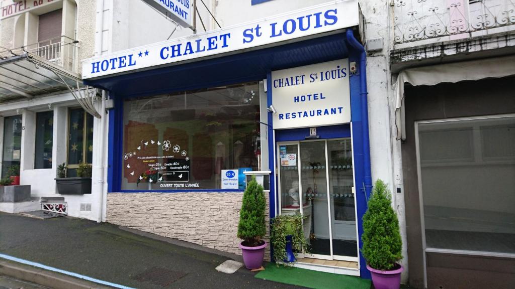 un magasin devant un bâtiment avec des plantes devant dans l'établissement Chalet Saint Louis, à Lourdes