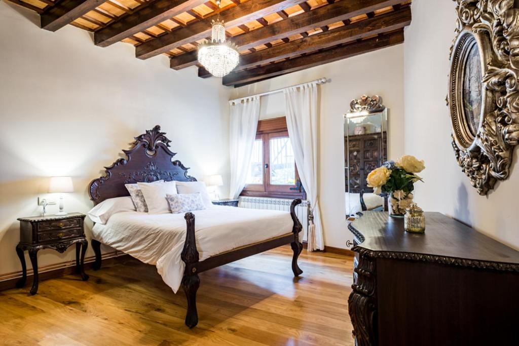 Un dormitorio con una cama, una mesa y un espejo. en El Aserradero, en La Alberca