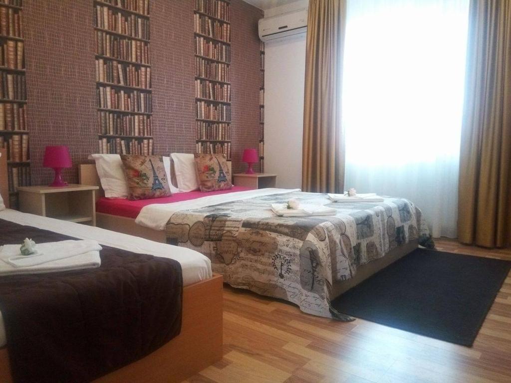 City Comfort Villa في بوخارست: غرفة نوم بسريرين ونافذة كبيرة