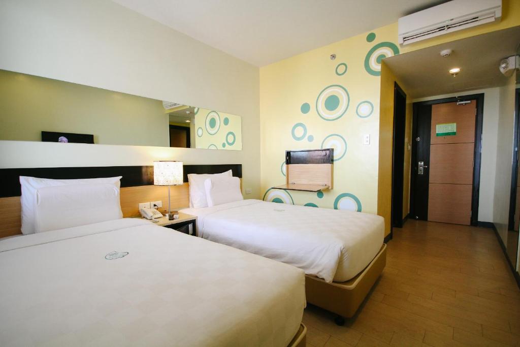 a hotel room with two beds and a tv at Go Hotels Iloilo in Iloilo City