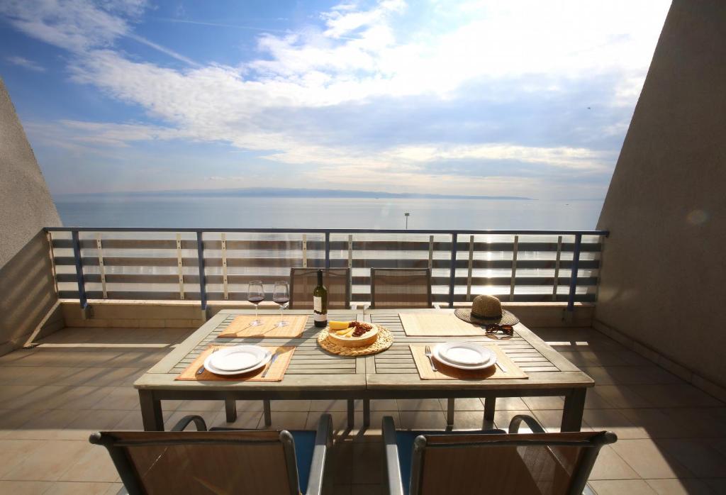 stół na balkonie z widokiem na ocean w obiekcie Split on the beach, 2 floors & wide terrace w Splicie