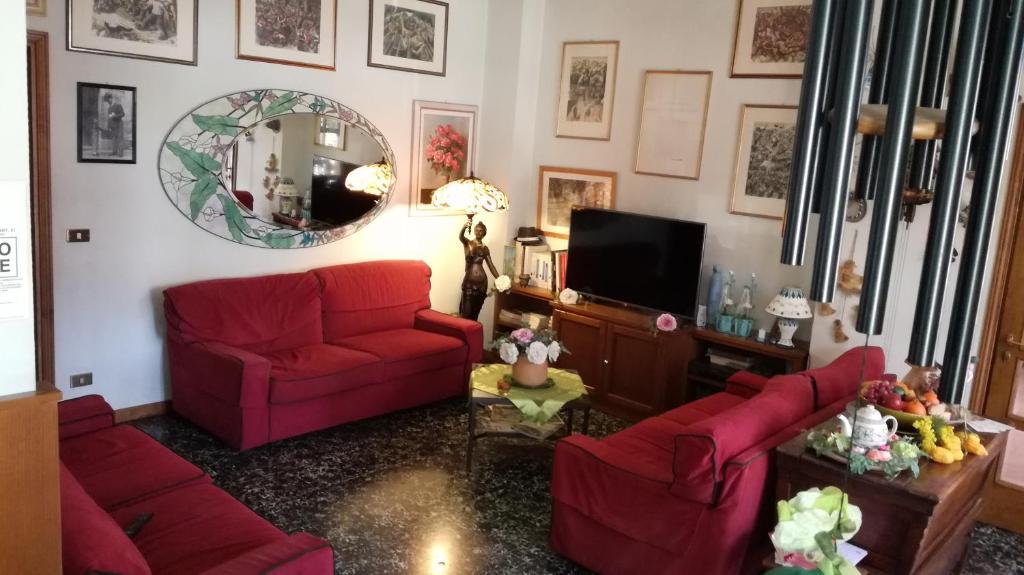 a living room with red couches and a mirror at Albergo Le Rose in Pistoia