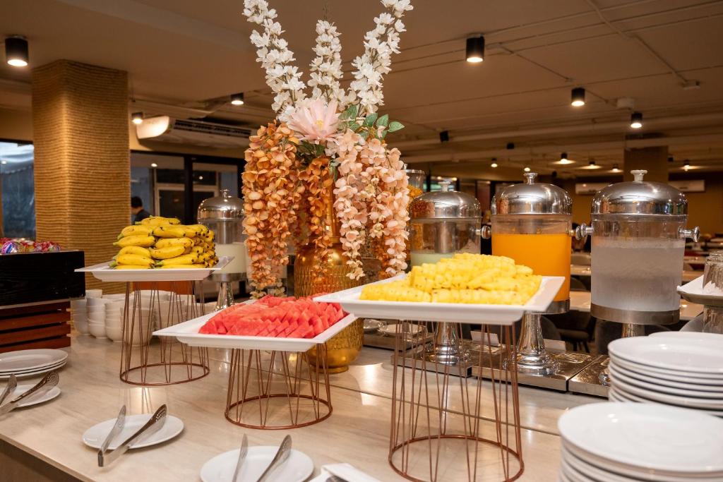 A spacious buffet counter with fruit, juice, water, and serving ware.