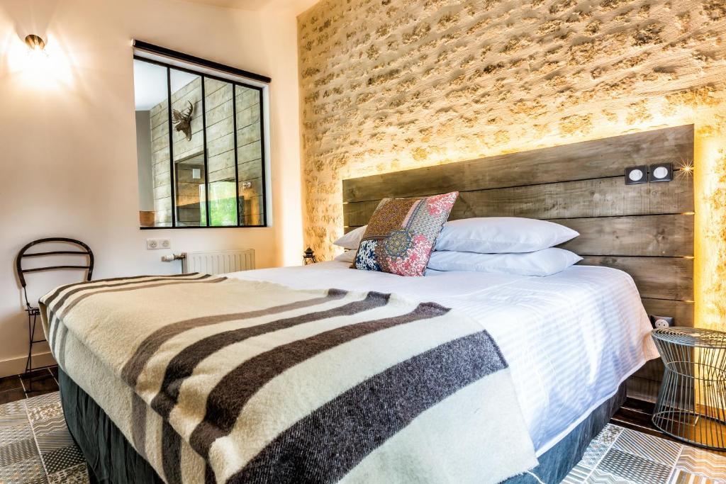 1 dormitorio con 1 cama grande y pared de ladrillo en Gîte "Le Caribou" - Le Clos de Landrais, en Landrais