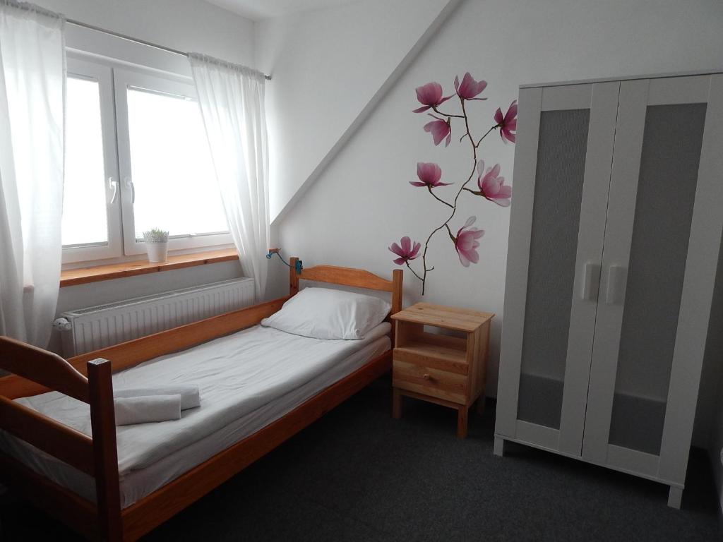 een kleine slaapkamer met een bed en een raam bij Dom św. Józefa in Szczecin