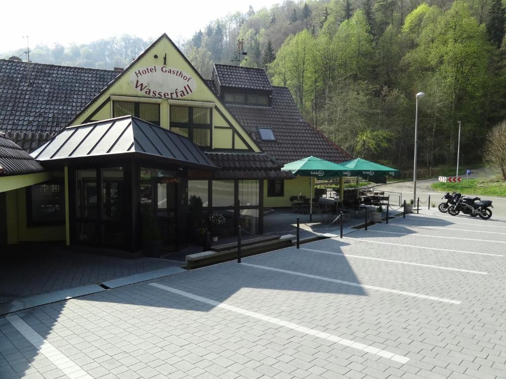 ein Gebäude mit einem Parkplatz mit Motorradparker darin in der Unterkunft Hotel zum Wasserfall Garni in Oberndorf