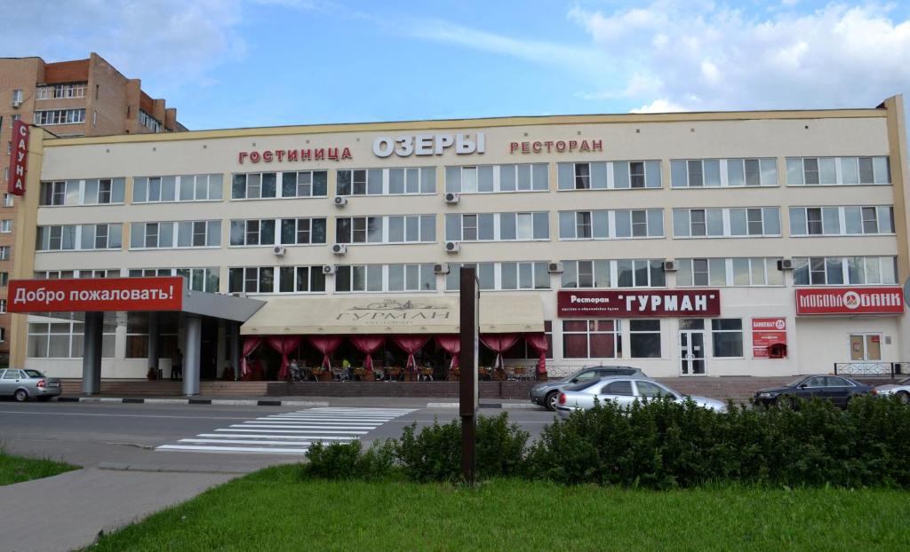un grande edificio bianco con auto parcheggiate in un parcheggio di Ozery a Ozëry