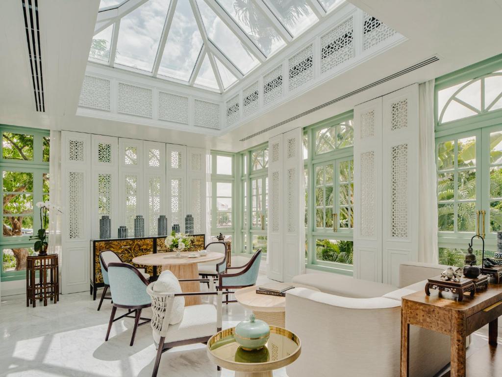 A bright glass-roofed conservatory filled with seating and garden views.