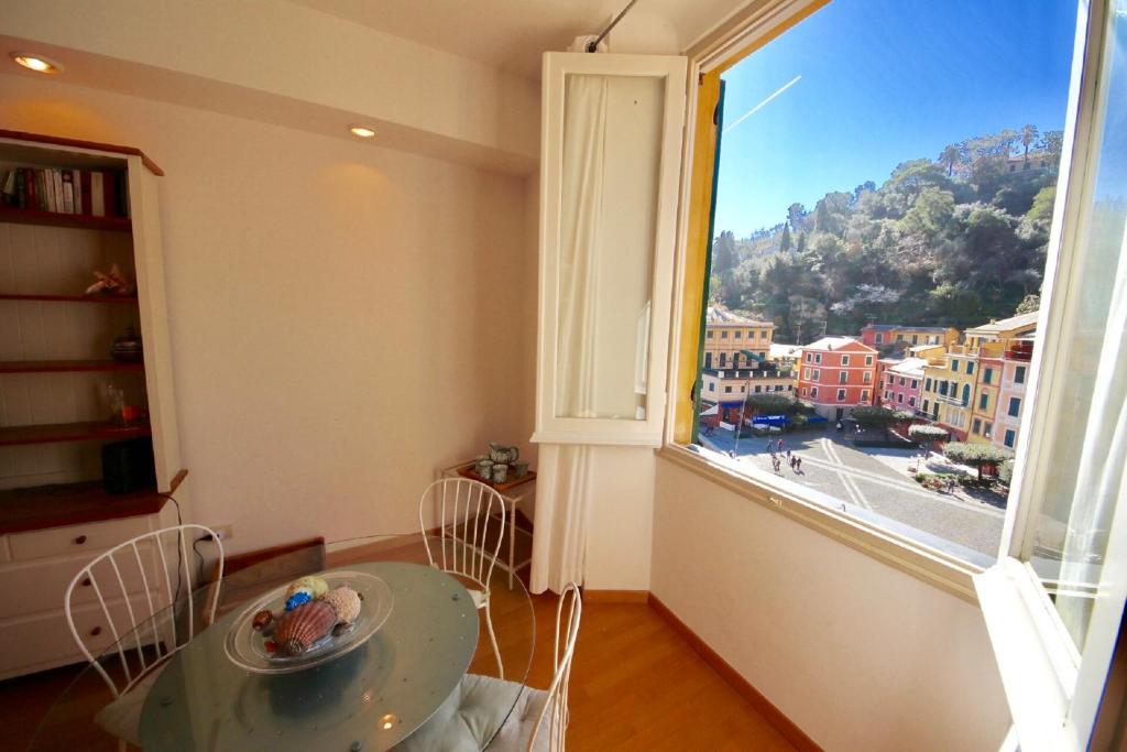 a room with a table and a large window at Vela Portofino by KlabHouse in Portofino