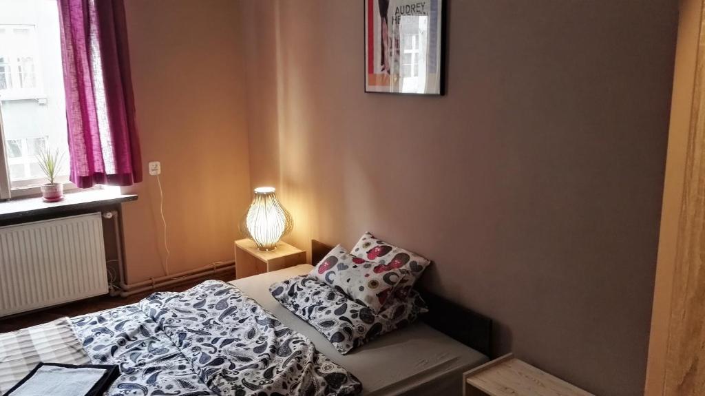 een kleine slaapkamer met een bed en een lamp bij Libroom in Krakau