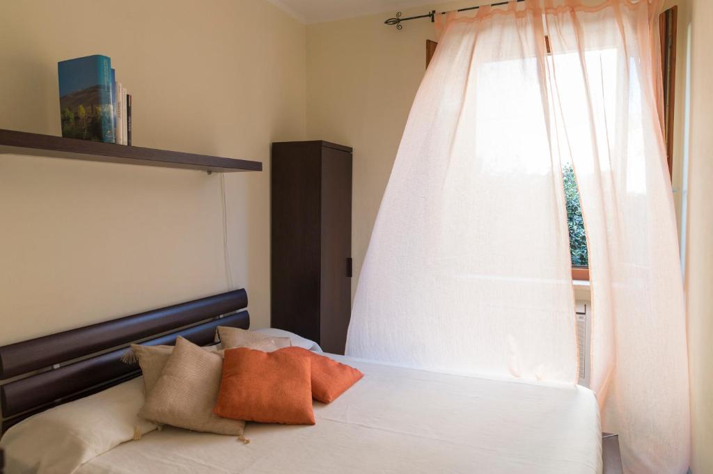 マルチャーナ・マリーナにあるAppartamenti Le Primuleのベッドルーム1室(窓、白いベッド1台付)