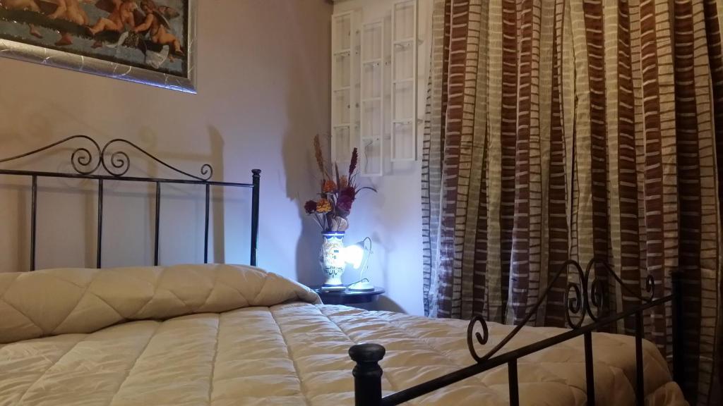 a bedroom with a bed and a window with curtains at B&B Mannalà in Agrigento