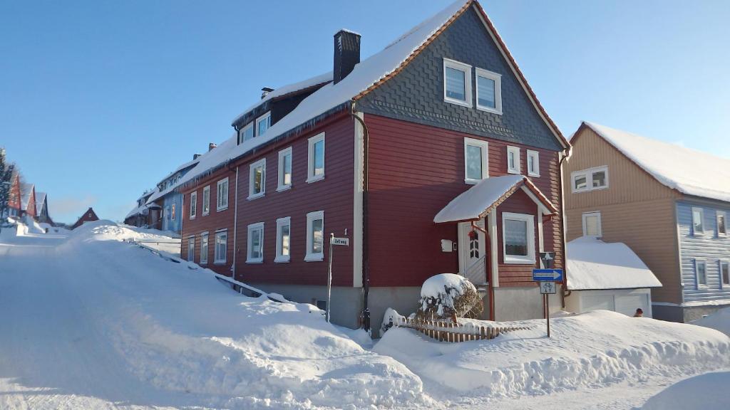 una casa está cubierta de nieve en una calle en Fischer, en Clausthal-Zellerfeld