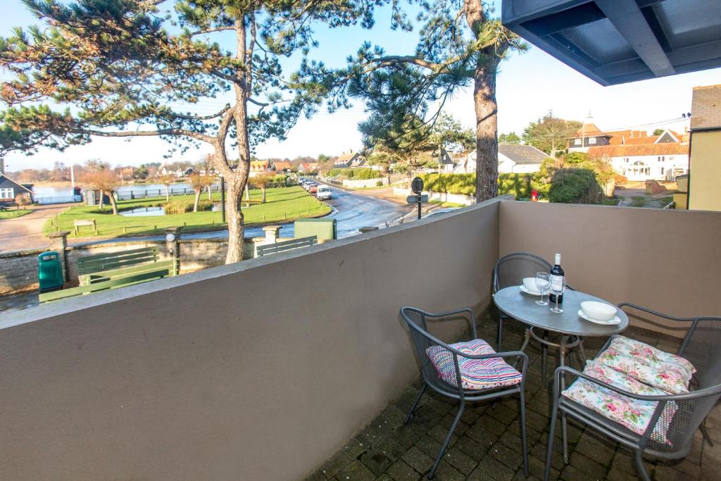 a patio with a table and chairs and a view of a park at Boat Lake in Thorpeness