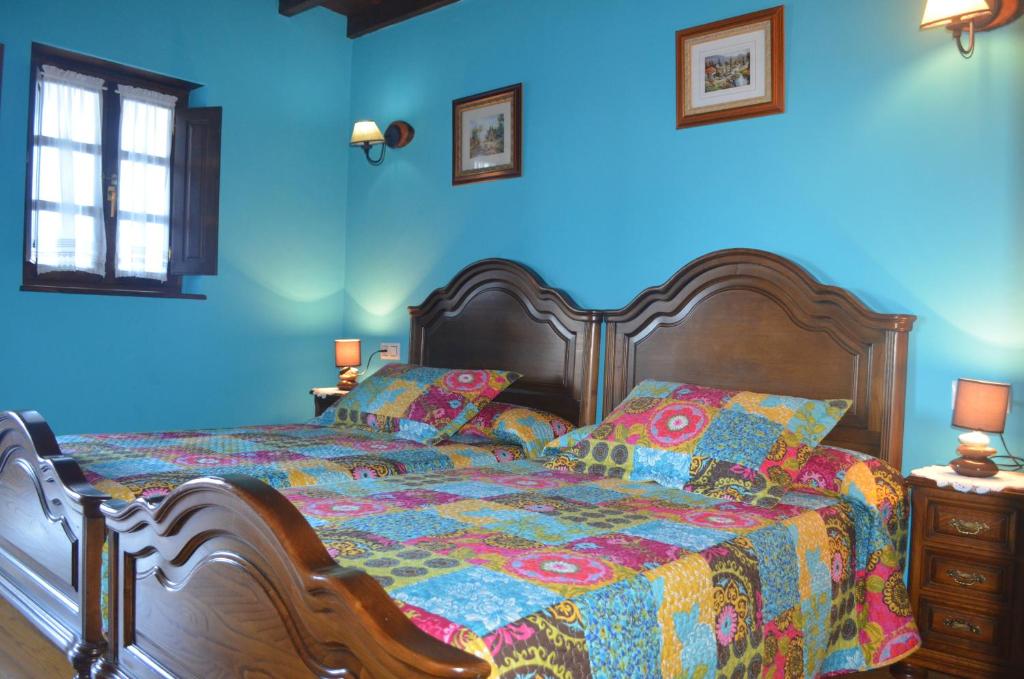 a bedroom with a bed with a colorful quilt at La Corrada in Priede