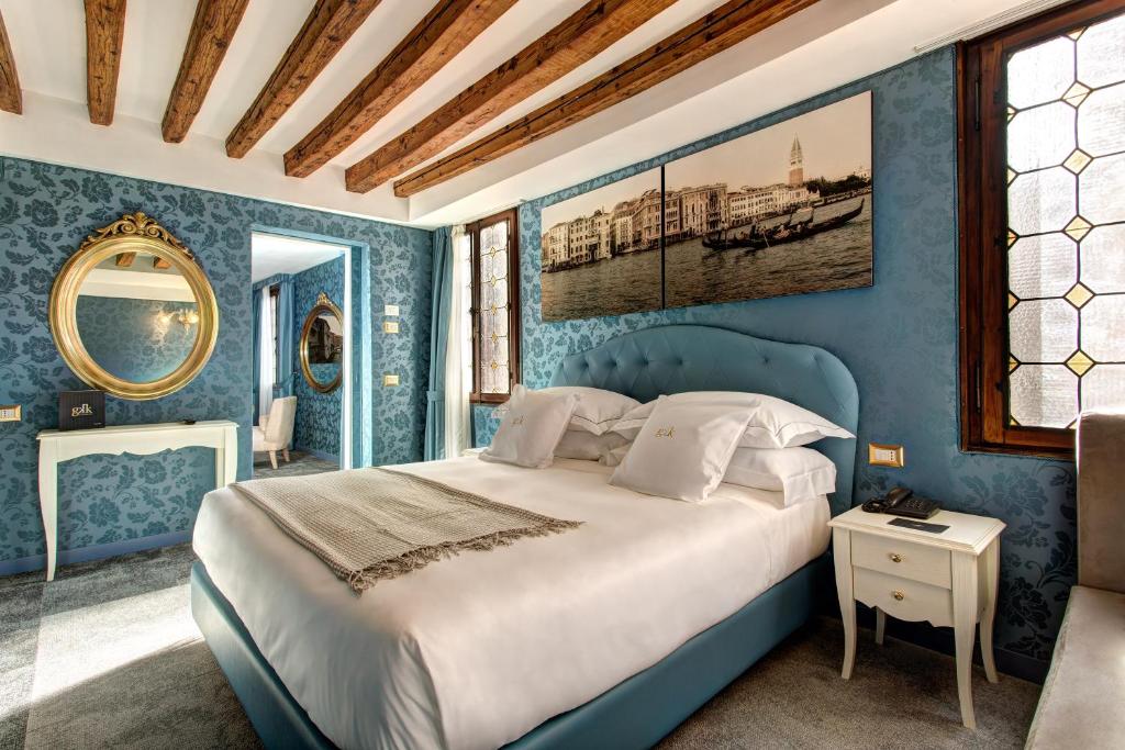 Dormitorio azul con cama y espejo en GKK Exclusive Private suite Venezia, en Venecia